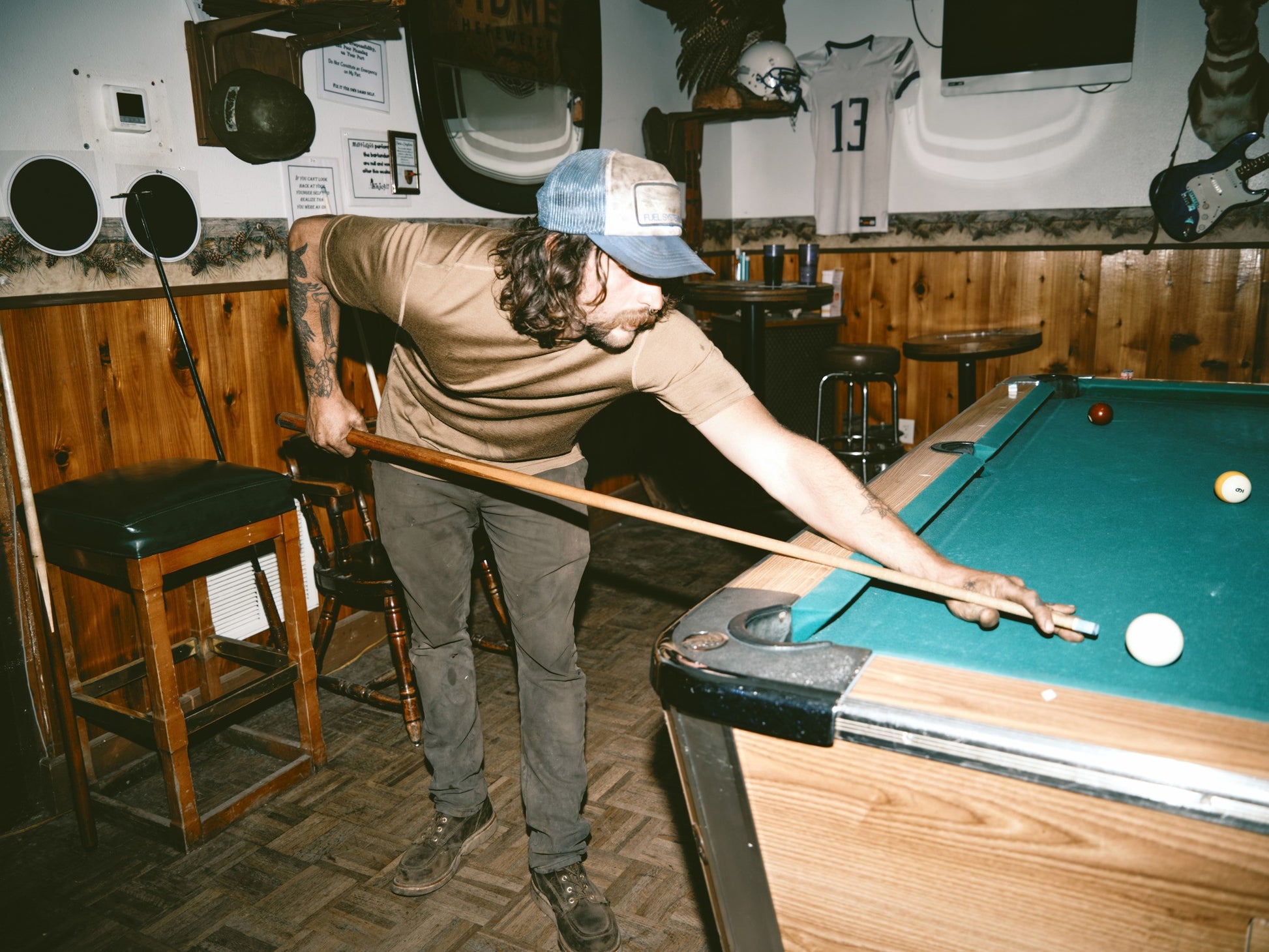 Man playing pool wearing a Filson merino wool t-shirt