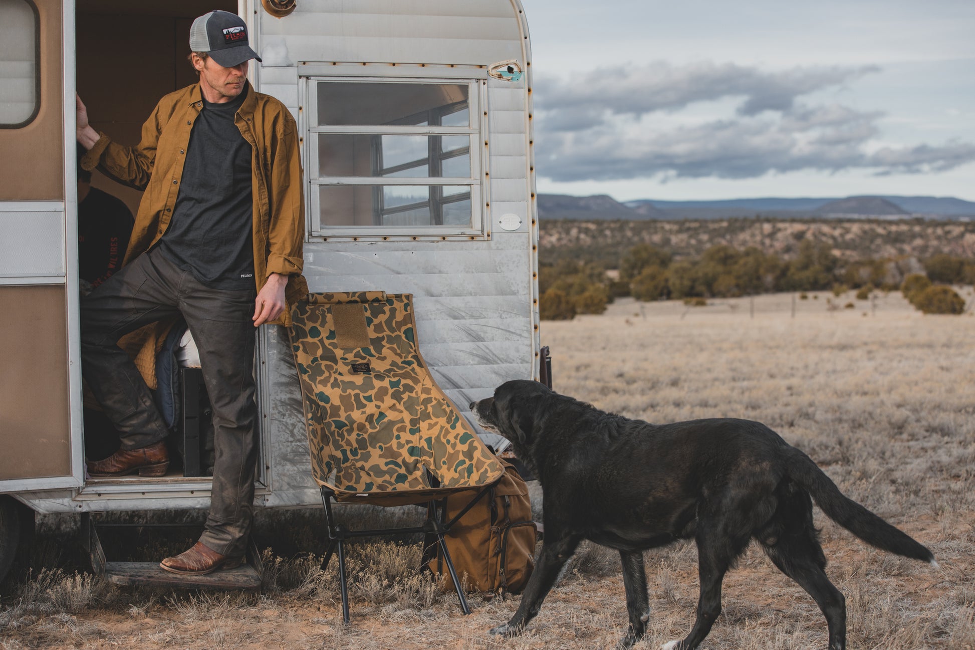 Man stepping out of a camper wearing a dark navy Filson 210G Merino Wool Short Sleeve Crew Shirt