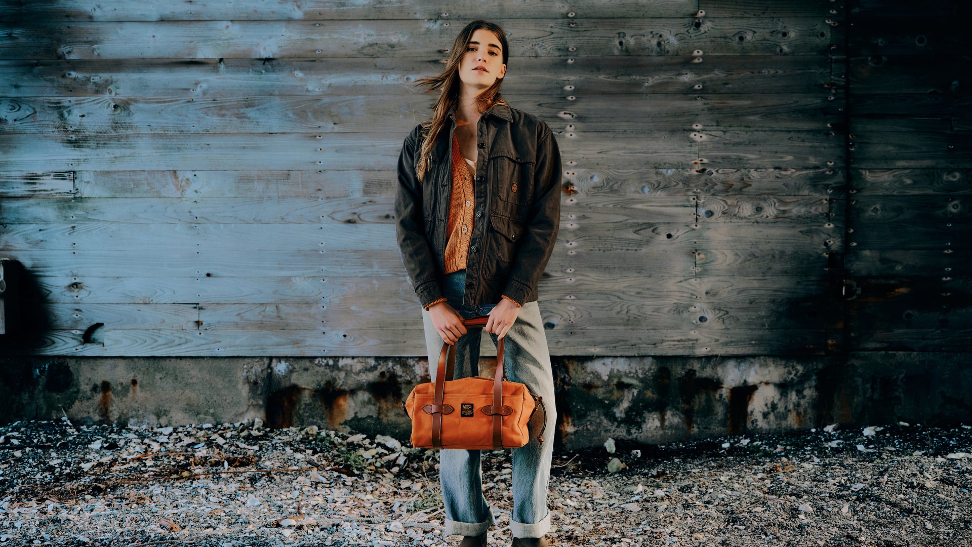 woman wearing a filson jacket and holding a filson bag